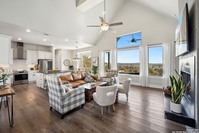 living area featuring visible vents, high vaulted ceiling, dark wood finished floors, recessed lighting, and a fireplace