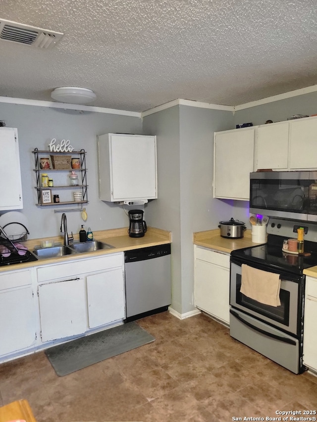 kitchen with visible vents, light countertops, a textured ceiling, a sink, and appliances with stainless steel finishes