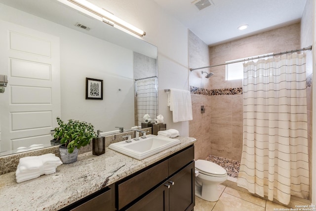 full bath with visible vents, toilet, a tile shower, tile patterned flooring, and vanity