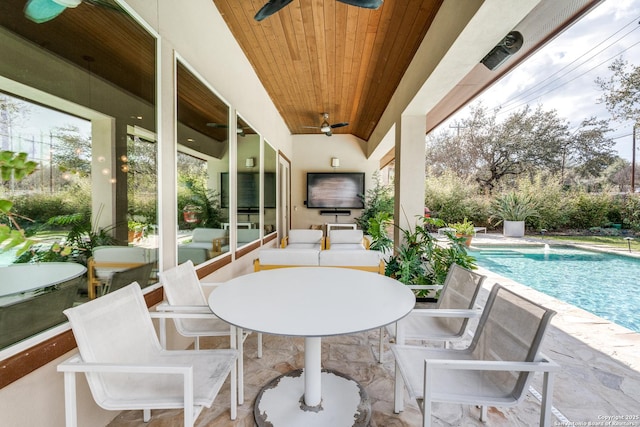 view of patio / terrace featuring outdoor dining space, a ceiling fan, and a fenced in pool