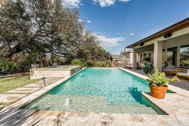 view of swimming pool with a patio area and a pool with connected hot tub