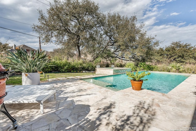 outdoor pool with a patio area and a hot tub