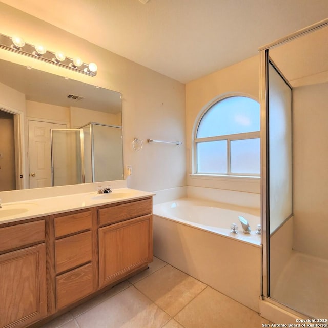 bathroom with tile patterned flooring, visible vents, double vanity, a stall shower, and a sink