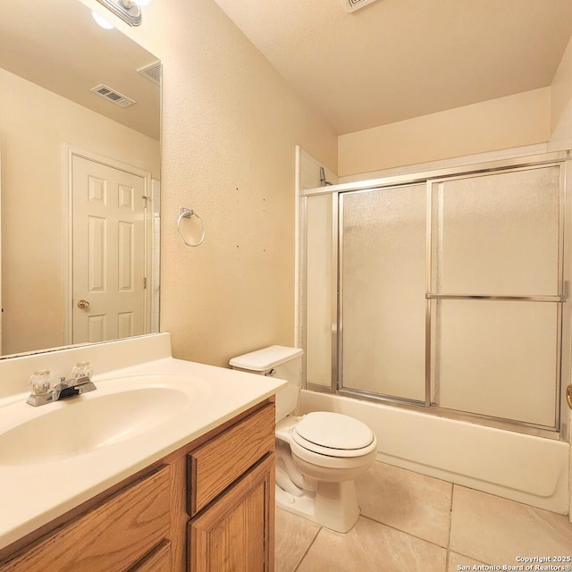 full bath featuring visible vents, toilet, shower / bath combination with glass door, tile patterned floors, and vanity