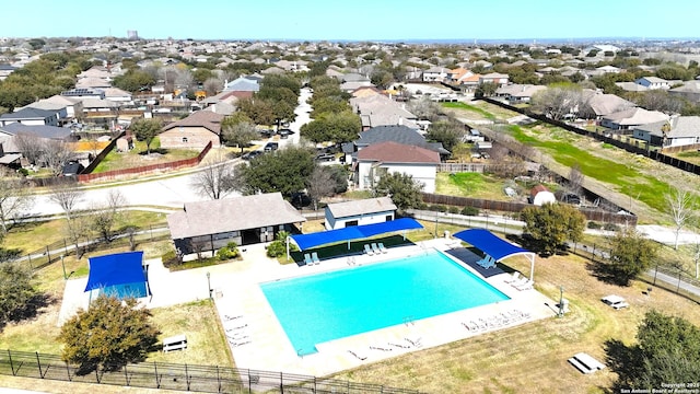 view of swimming pool with a residential view and fence