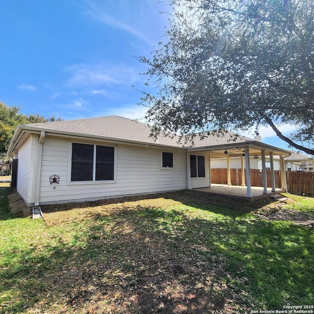 back of property featuring a yard, a patio, and fence