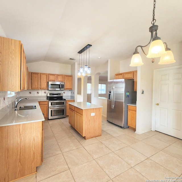 kitchen featuring a sink, stainless steel appliances, a center island, and light countertops