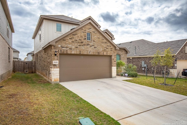 traditional-style home featuring brick siding, board and batten siding, a front lawn, fence, and concrete driveway