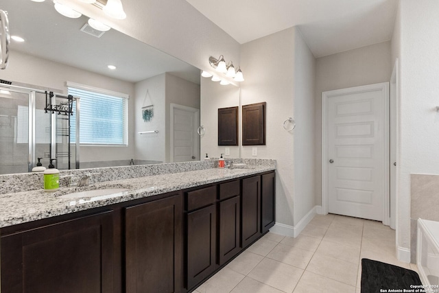 bathroom with tile patterned floors, double vanity, a shower stall, and a sink