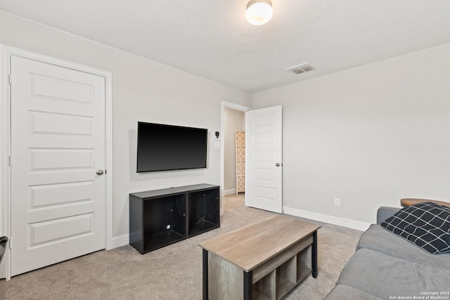 living area with visible vents, baseboards, a textured ceiling, and carpet flooring