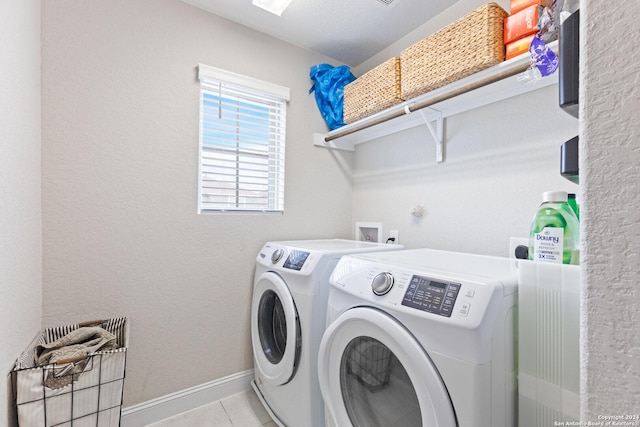 laundry room featuring laundry area, light tile patterned floors, baseboards, and washer and clothes dryer