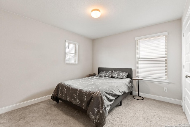 carpeted bedroom featuring baseboards