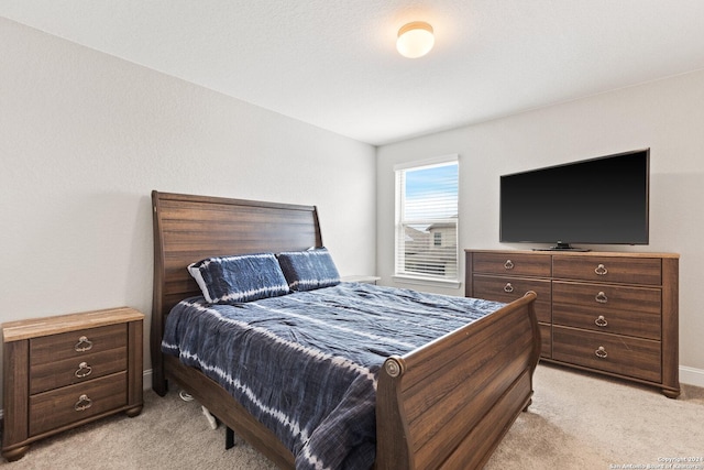 bedroom featuring baseboards and light carpet