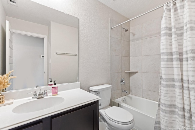 bathroom with visible vents, vanity, shower / tub combo, and a textured wall