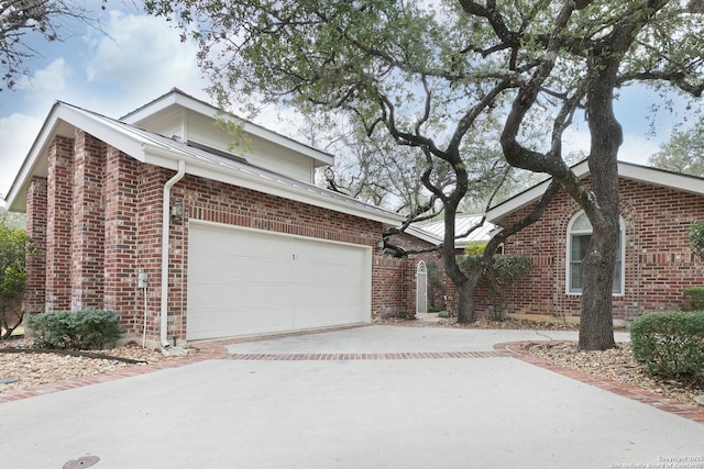 view of property exterior with brick siding, driveway, and a garage