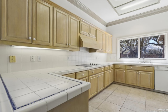 kitchen with tile countertops, white dishwasher, ornamental molding, a sink, and under cabinet range hood