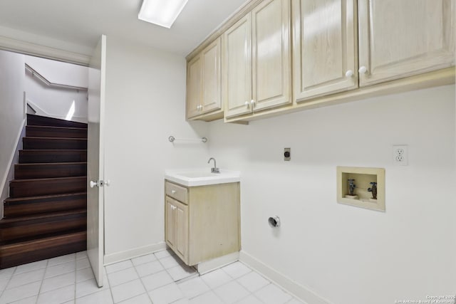 washroom with baseboards, hookup for an electric dryer, cabinet space, a sink, and washer hookup