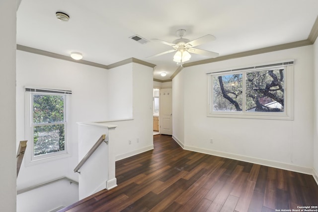unfurnished room featuring visible vents, plenty of natural light, crown molding, and wood finished floors