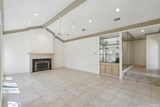 unfurnished living room featuring lofted ceiling with beams, visible vents, a high end fireplace, and ornamental molding
