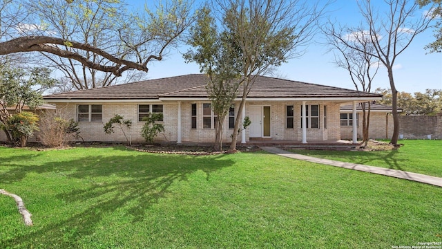 ranch-style house with a front lawn, covered porch, and brick siding