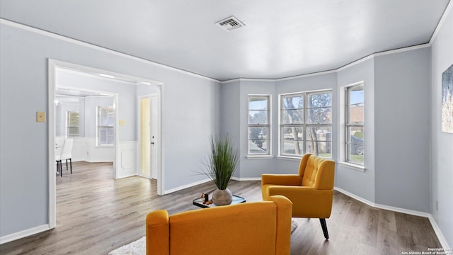 living area featuring visible vents, plenty of natural light, and wood finished floors