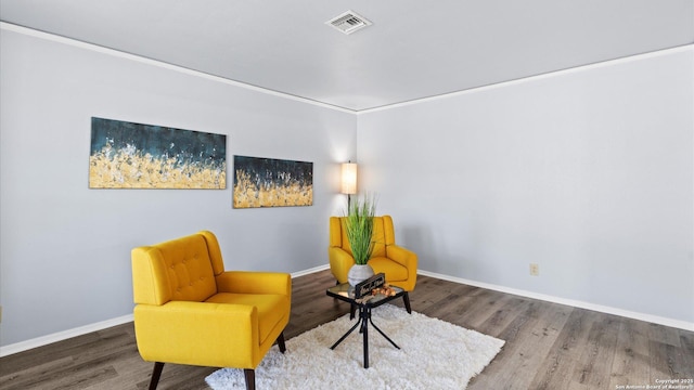 sitting room with visible vents, baseboards, and wood finished floors