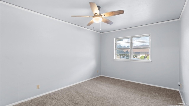 carpeted spare room featuring baseboards, ornamental molding, and a ceiling fan