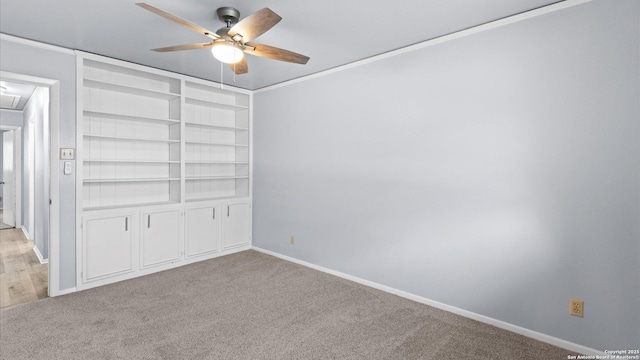 empty room with light carpet, baseboards, attic access, and a ceiling fan