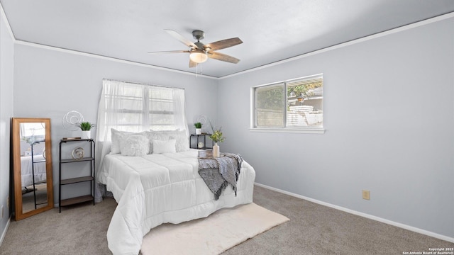 carpeted bedroom with ceiling fan, multiple windows, baseboards, and ornamental molding