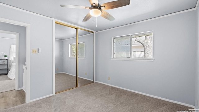 unfurnished bedroom featuring baseboards, a closet, carpet floors, and ornamental molding