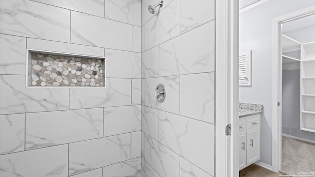 bathroom with vanity and a tile shower