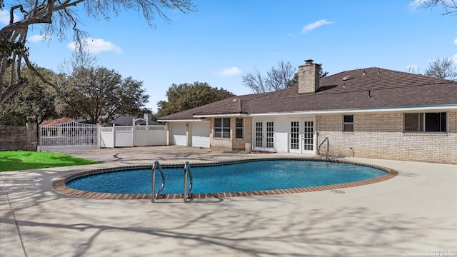 view of pool featuring a fenced in pool, fence, french doors, a patio, and a gate