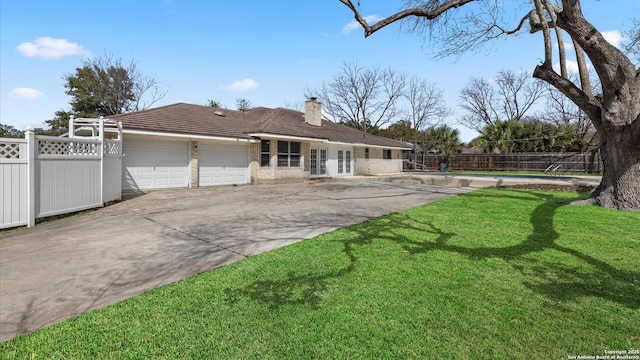 view of front of house featuring a front yard, fence, an attached garage, a chimney, and concrete driveway