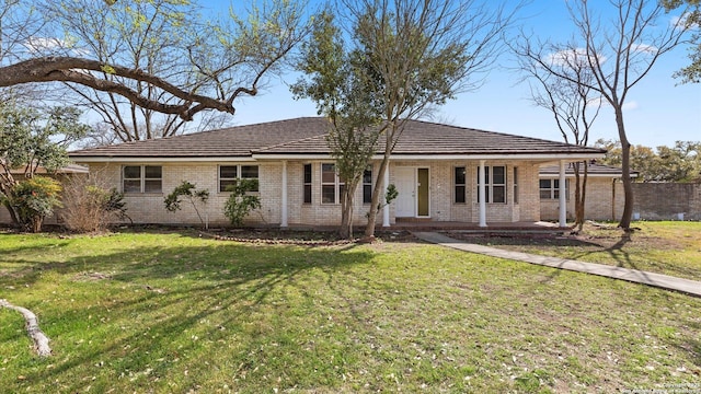 ranch-style home with brick siding, covered porch, and a front lawn