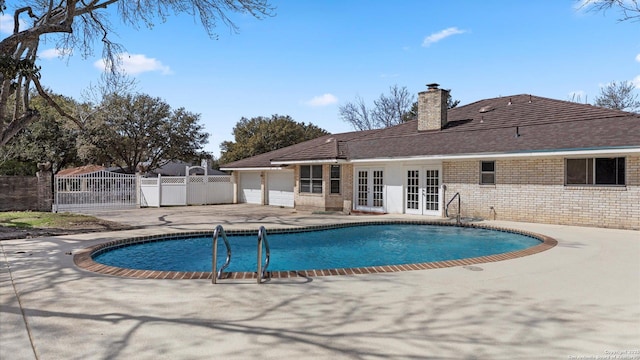 view of swimming pool featuring a fenced in pool, fence, french doors, a patio area, and a gate