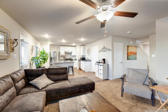 living area with light wood-style floors and ceiling fan