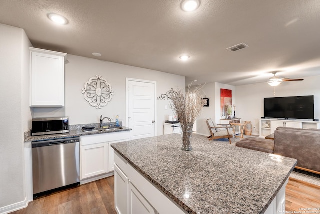 kitchen featuring visible vents, light wood-style flooring, stainless steel appliances, and a sink