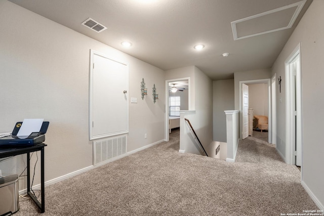 hallway featuring carpet, an upstairs landing, visible vents, and baseboards