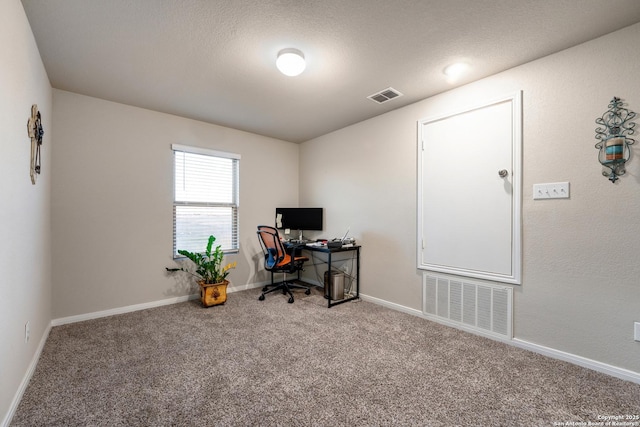 carpeted home office with visible vents, baseboards, and a textured ceiling