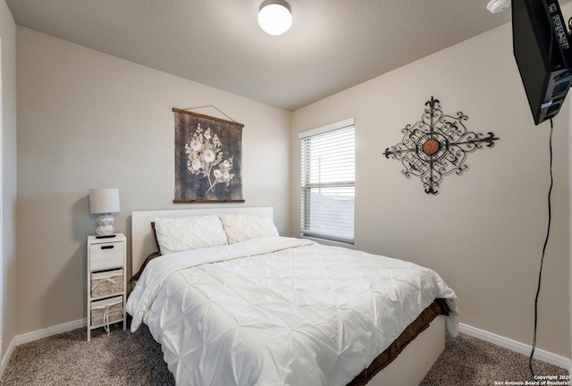 carpeted bedroom featuring baseboards and a textured ceiling