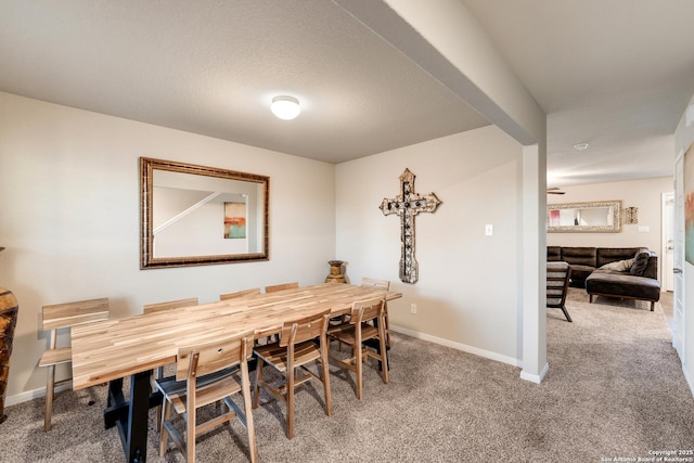 dining space with baseboards and carpet