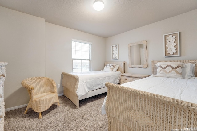 bedroom with light colored carpet, a textured ceiling, and baseboards