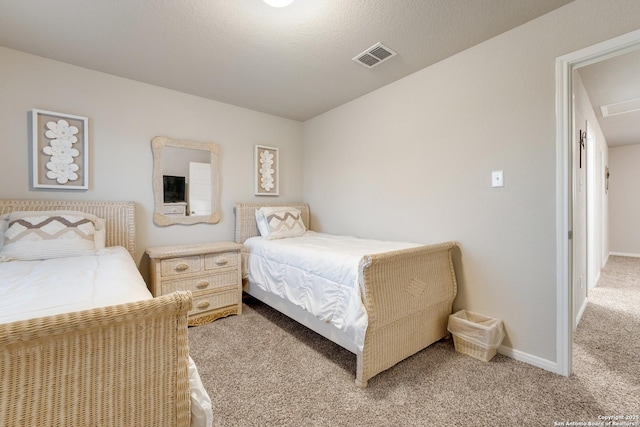 bedroom with visible vents, light carpet, a textured ceiling, and baseboards