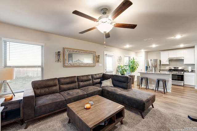 living room with recessed lighting, visible vents, light wood finished floors, and ceiling fan