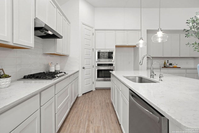 kitchen featuring a sink, stainless steel appliances, exhaust hood, and white cabinets