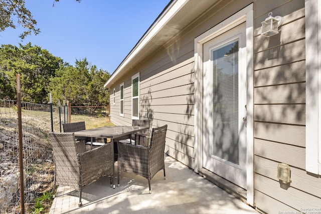 view of patio featuring outdoor dining space and fence