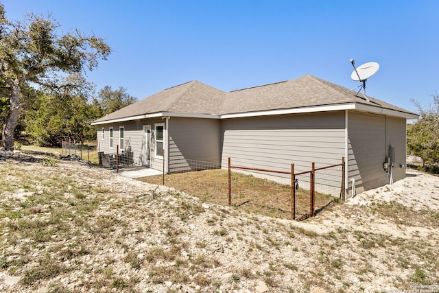 back of property featuring fence and roof with shingles