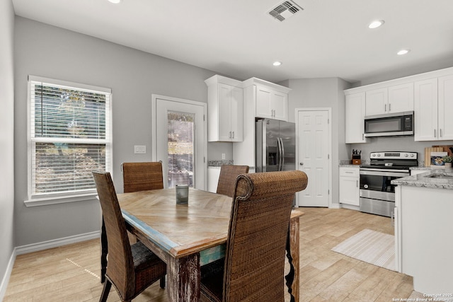 dining space with light wood finished floors, visible vents, recessed lighting, and baseboards