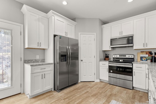 kitchen featuring light stone counters, recessed lighting, appliances with stainless steel finishes, light wood-style floors, and white cabinetry