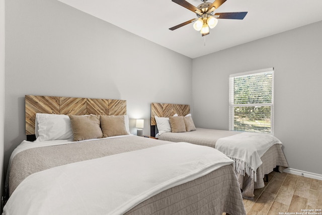 bedroom with light wood finished floors, ceiling fan, and baseboards